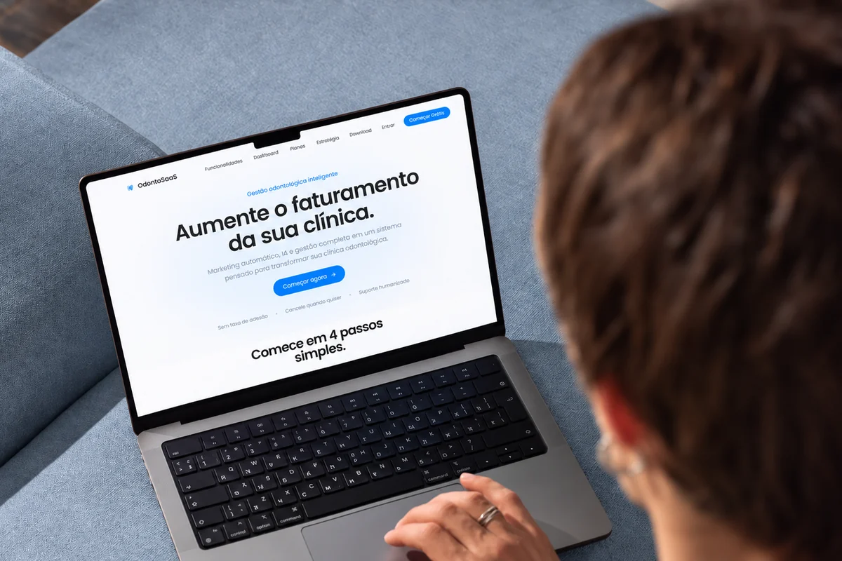 Pessoa no sofá usando o site do OdontoSaaS no notebook